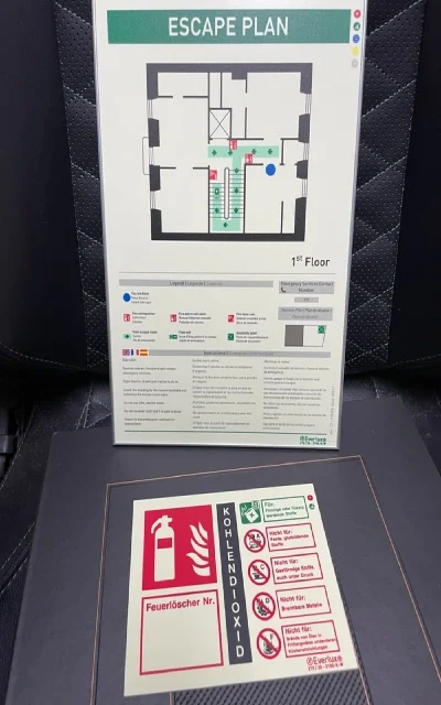 Fluchtplan für das erste Obergeschoss mit Notausgängen und Feuerlöscher-Symbolen.