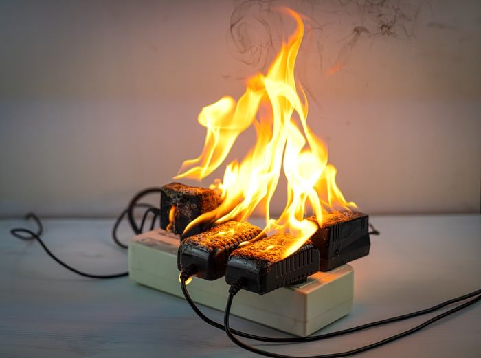 Drei elektronische Geräte, die auf einem Tisch brennen und Flammen erzeugen.